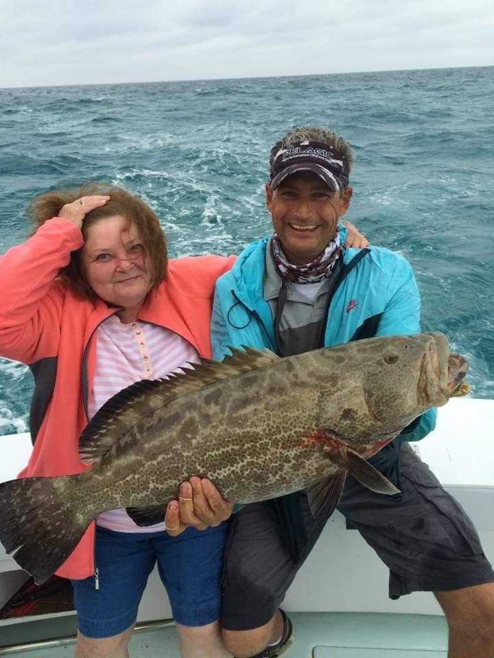 Anglers holding a large grouper on a Wild Bill Charters boat in Key West.